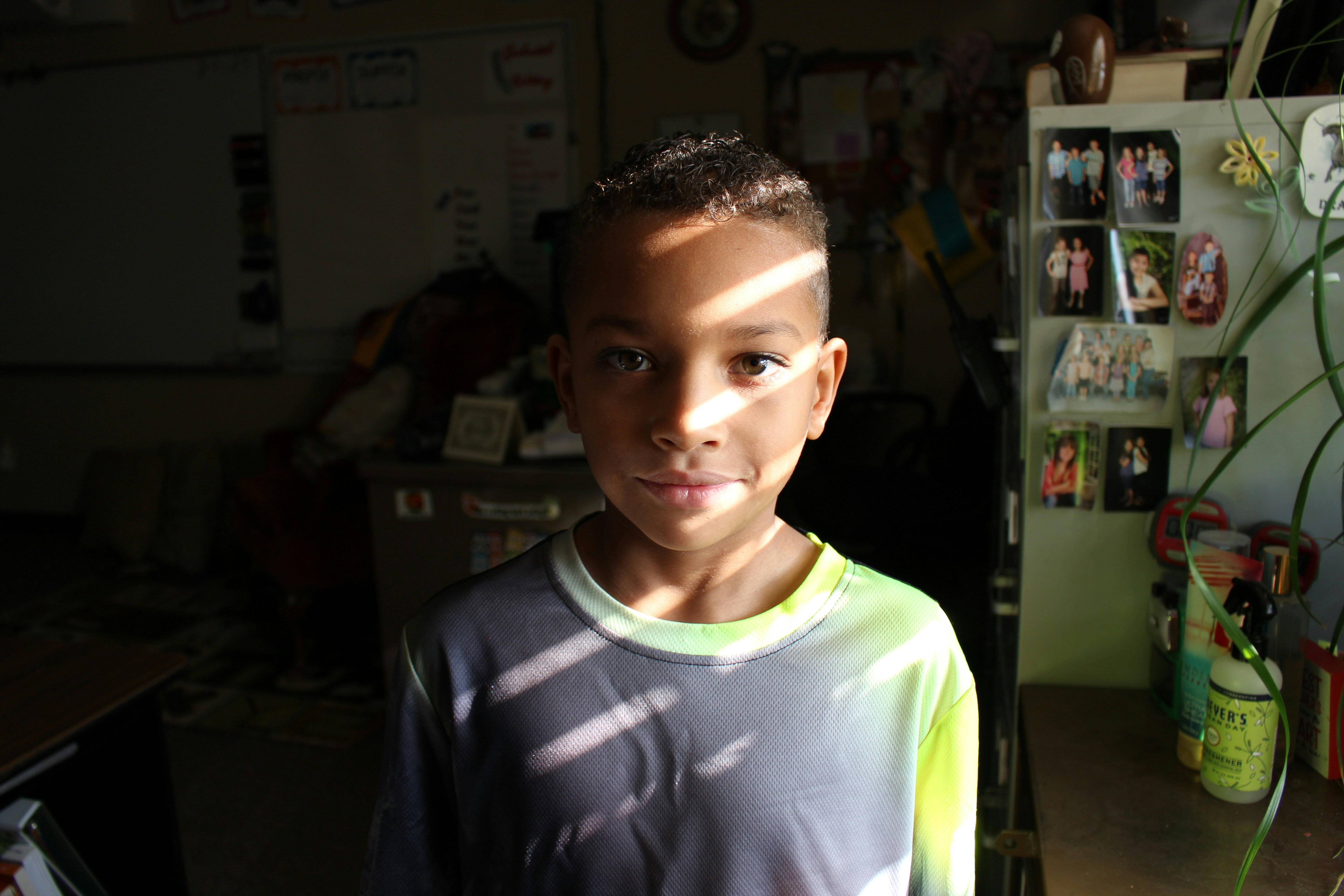 a young boy standing in front of a refrigerator