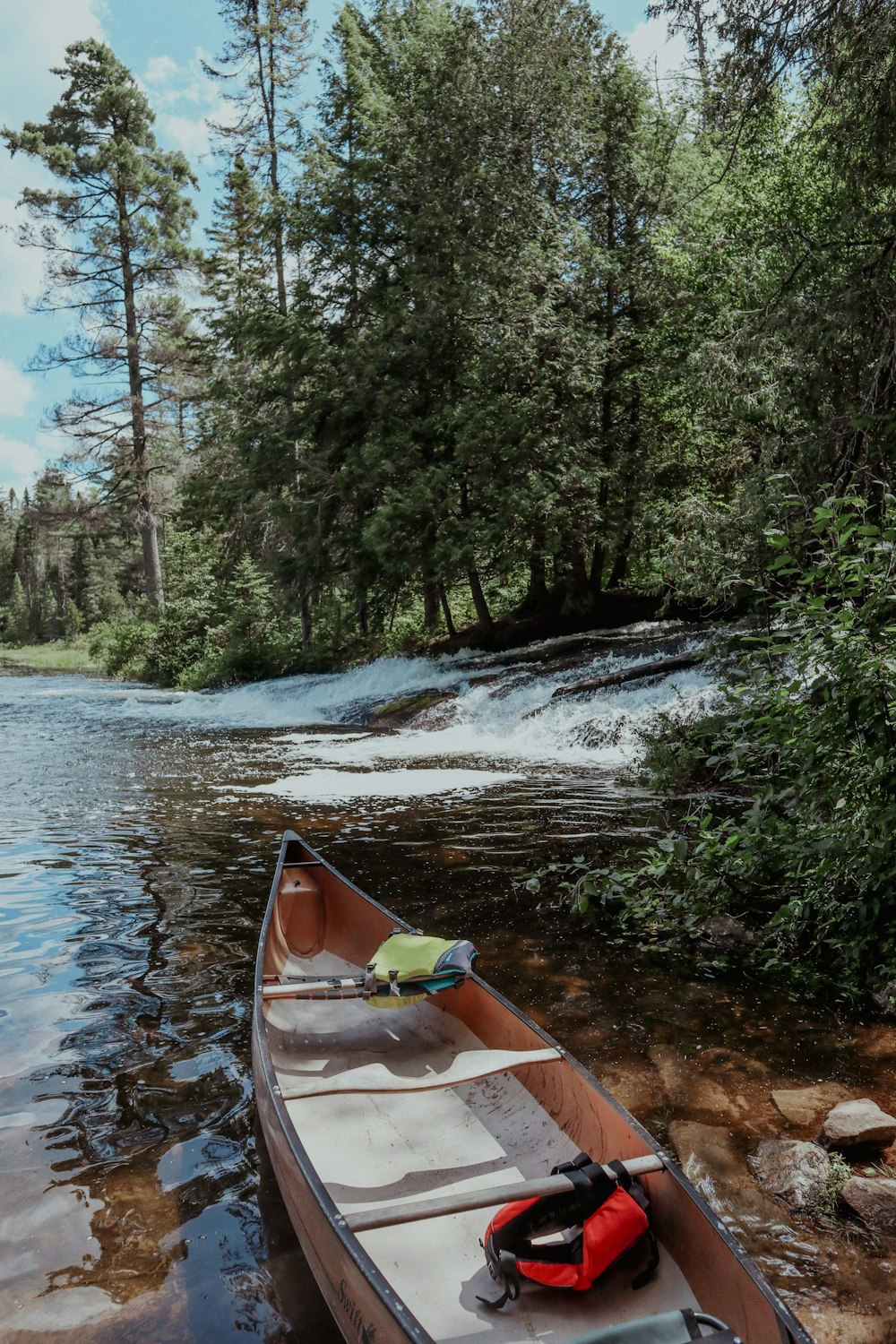 a canoe is sitting on the shore of a river