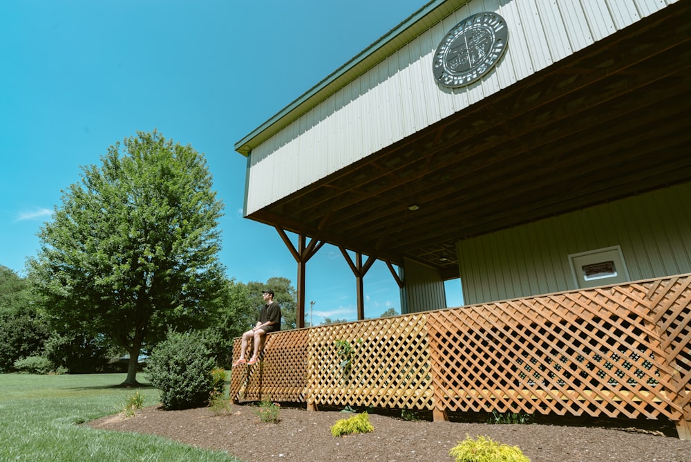 a man sitting on a wooden bench in front of a building