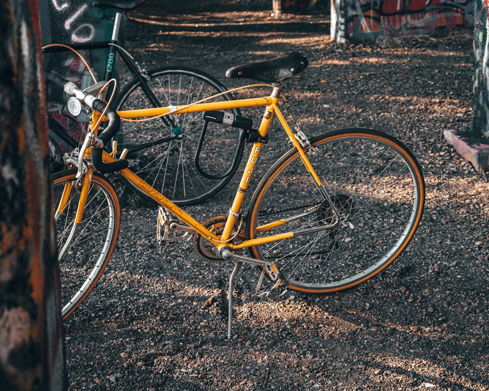 a yellow bicycle parked next to a tree