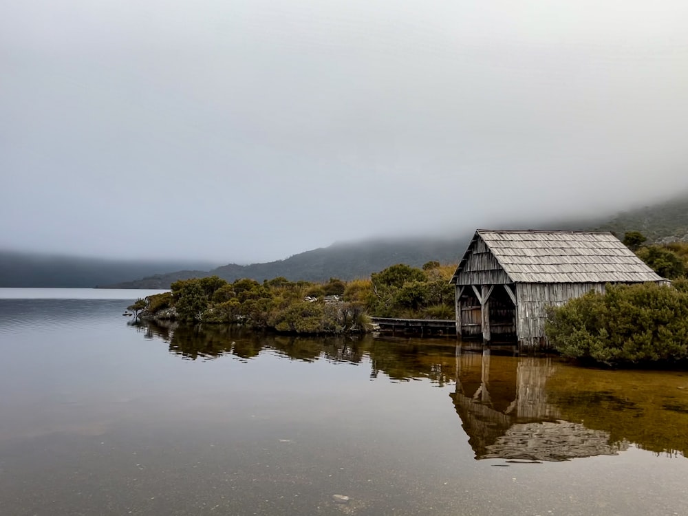 a boathouse on a lake surrounded by trees