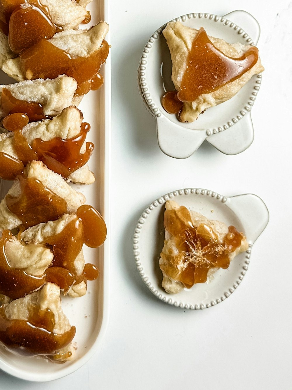 a white plate topped with slices of pie covered in caramel