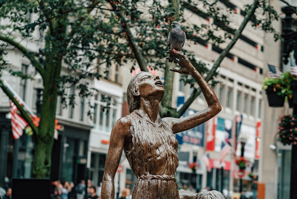 a statue of a woman holding a bird in her hand