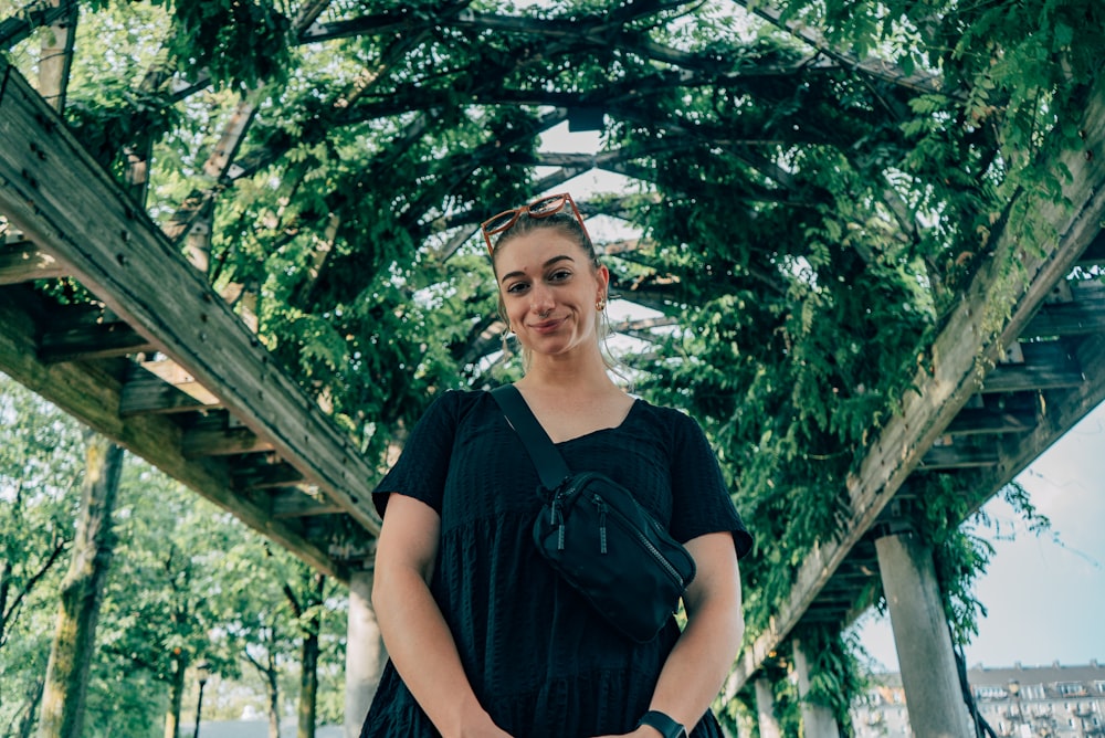 a woman in a black dress standing under a canopy