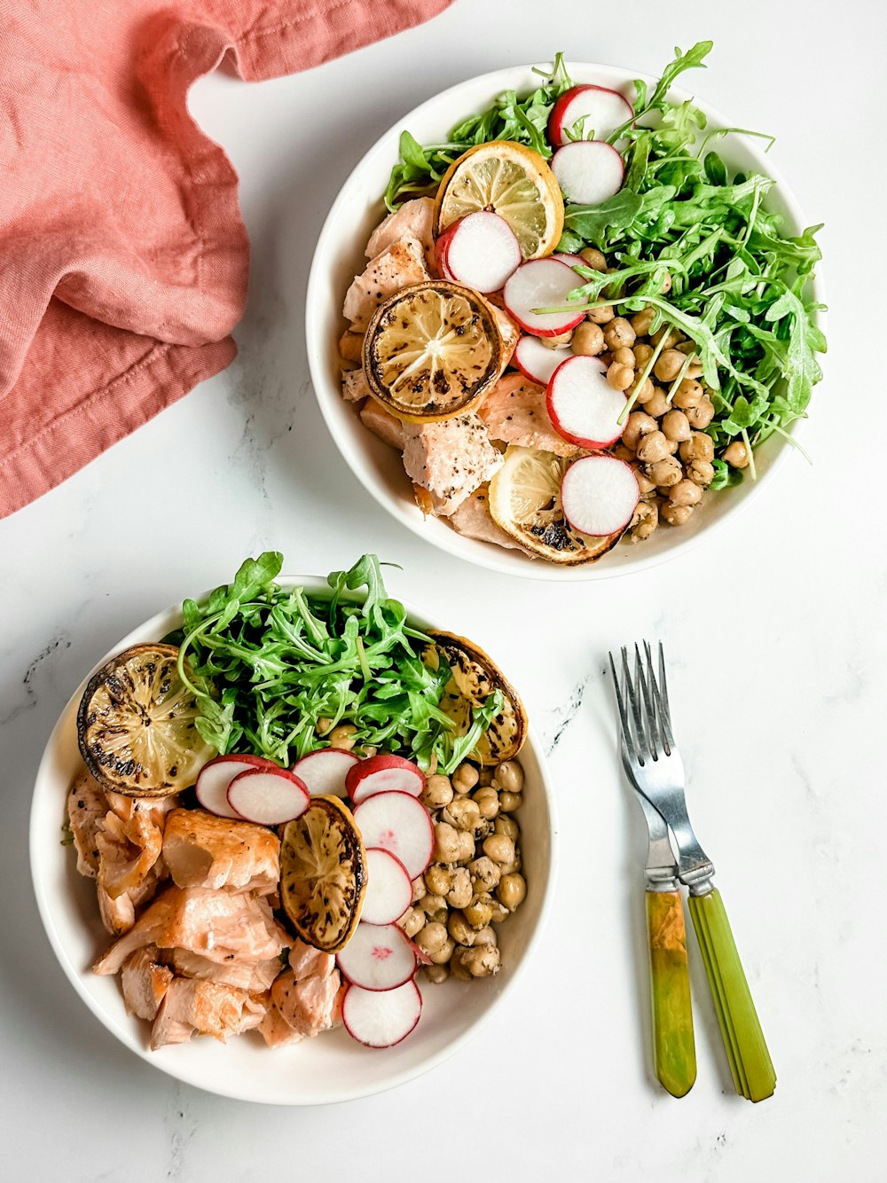 two bowls of food on a white table