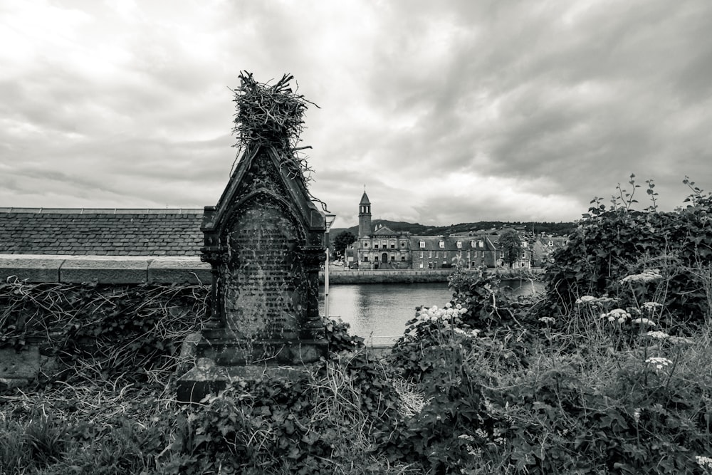 a black and white photo of a building near a body of water