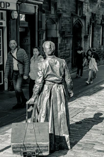 Traveler in stylish attire pulling a gold-accented Travora suitcase through a bustling city street