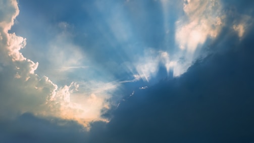 A comforting light shining through clouds, evoking hope and healing.