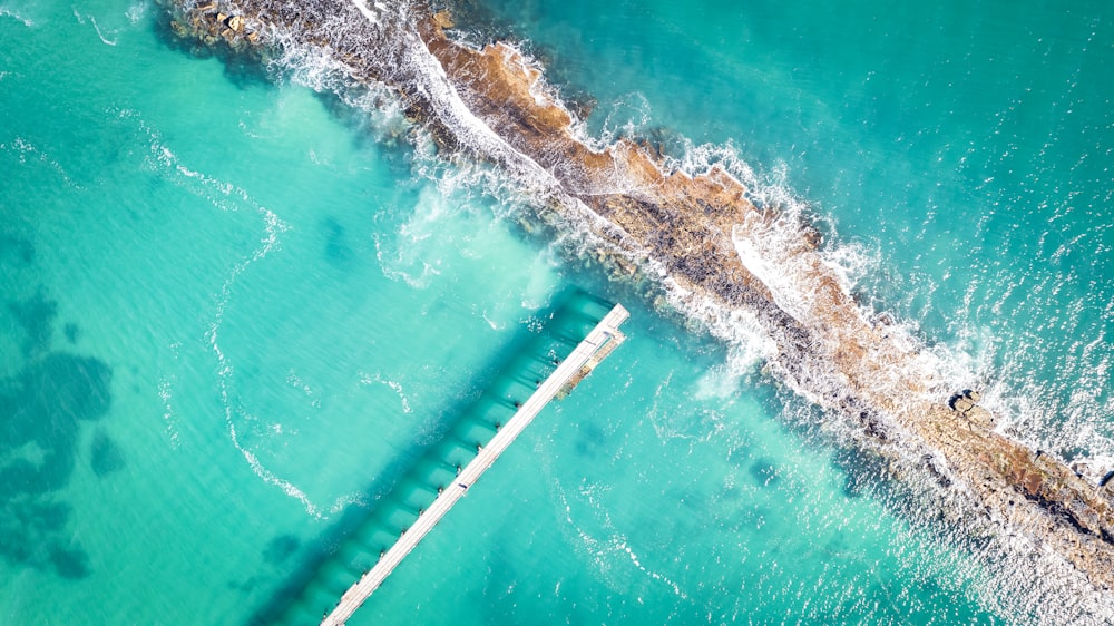 an aerial view of a pier in the ocean