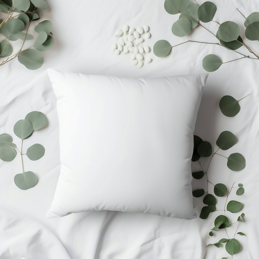 a white pillow sitting on top of a white bed