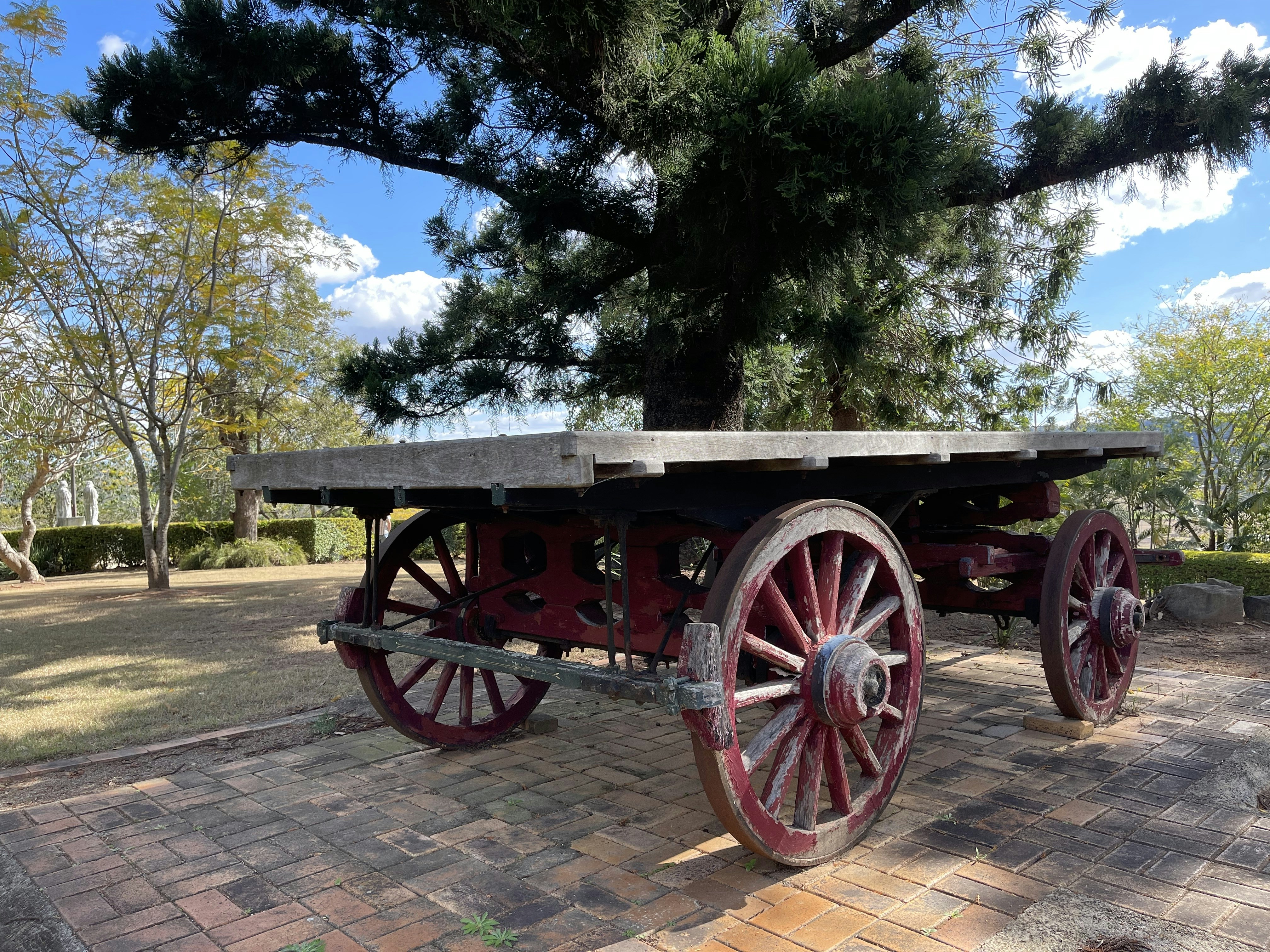 an old wooden cart sitting on top of a brick walkway