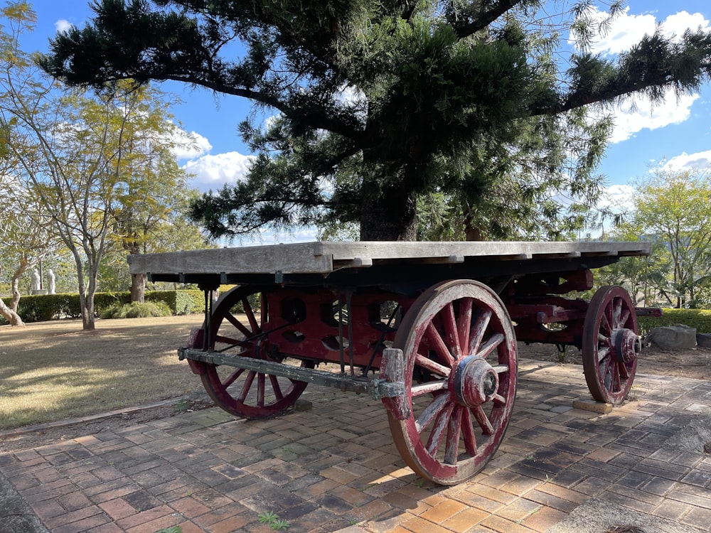 an old wooden cart sitting on top of a brick walkway