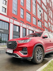 A stylish SUV parked in front of a modern business building.