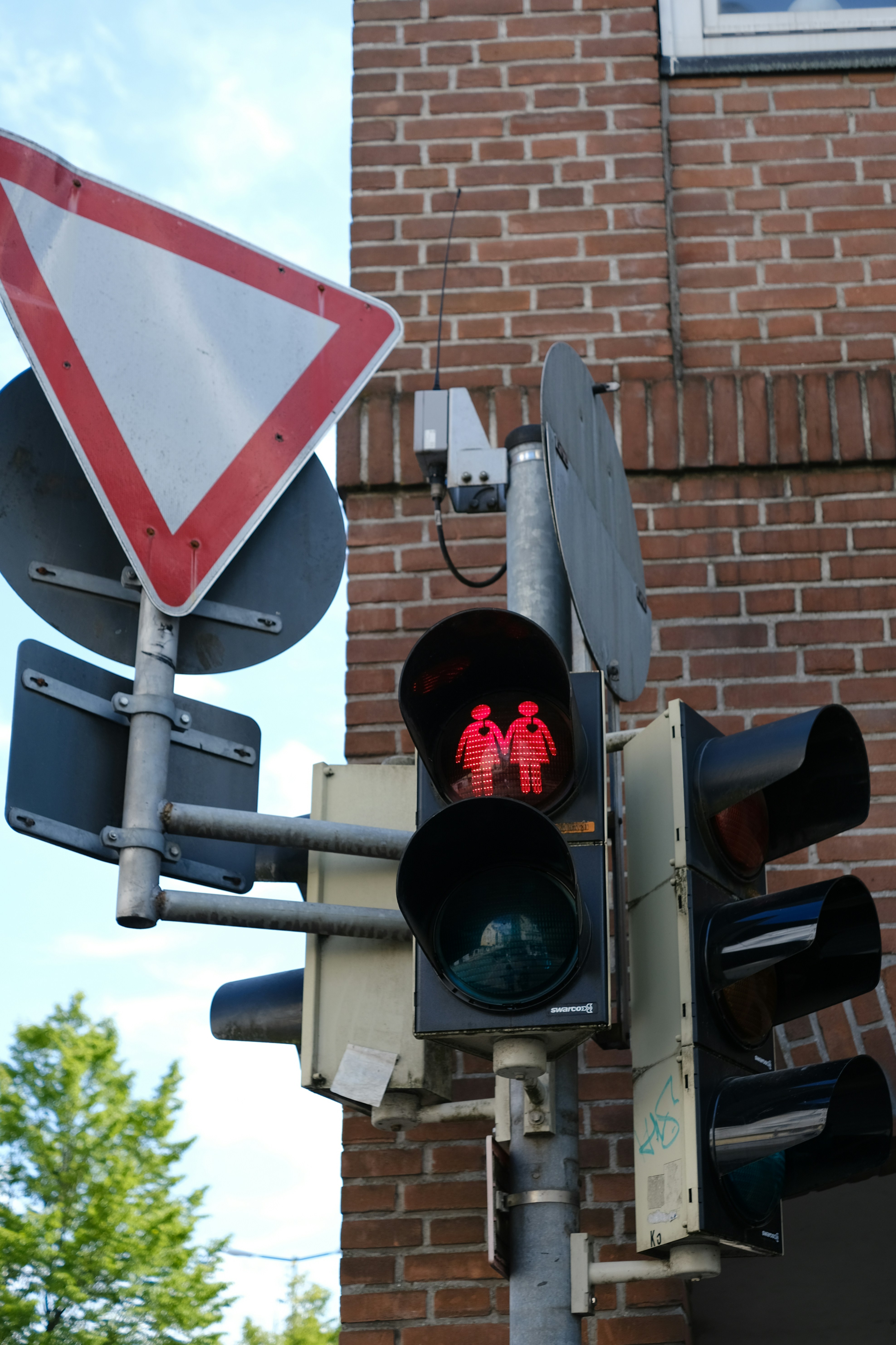 a red and white traffic light next to a brick building