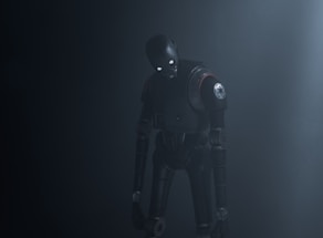 A humanoid robot with dark metallic body stands in a dimly lit environment, emitting an eerie presence. Its eyes glow white, providing a stark contrast to the dark surroundings. The robot's body is detailed with mechanical joints and a circular emblem on its shoulder.