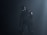 A humanoid robot with dark metallic body stands in a dimly lit environment, emitting an eerie presence. Its eyes glow white, providing a stark contrast to the dark surroundings. The robot's body is detailed with mechanical joints and a circular emblem on its shoulder.