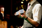 a man in a vest holding a box of money
