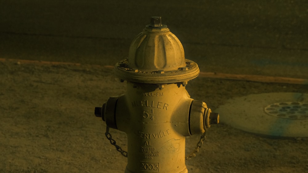 ein gelber Hydrant, der am Straßenrand sitzt