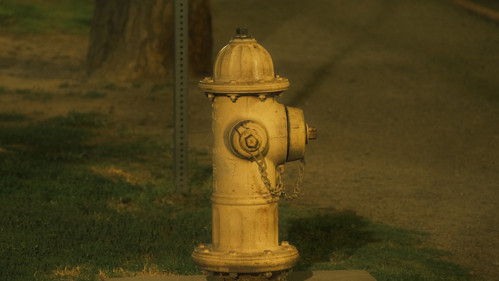 a yellow fire hydrant sitting on the side of a road