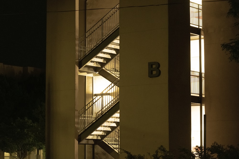 un bâtiment avec un escalier en colimaçon éclairé la nuit