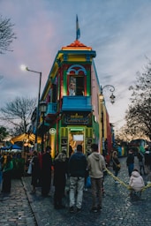 a group of people standing outside of a colorful building
