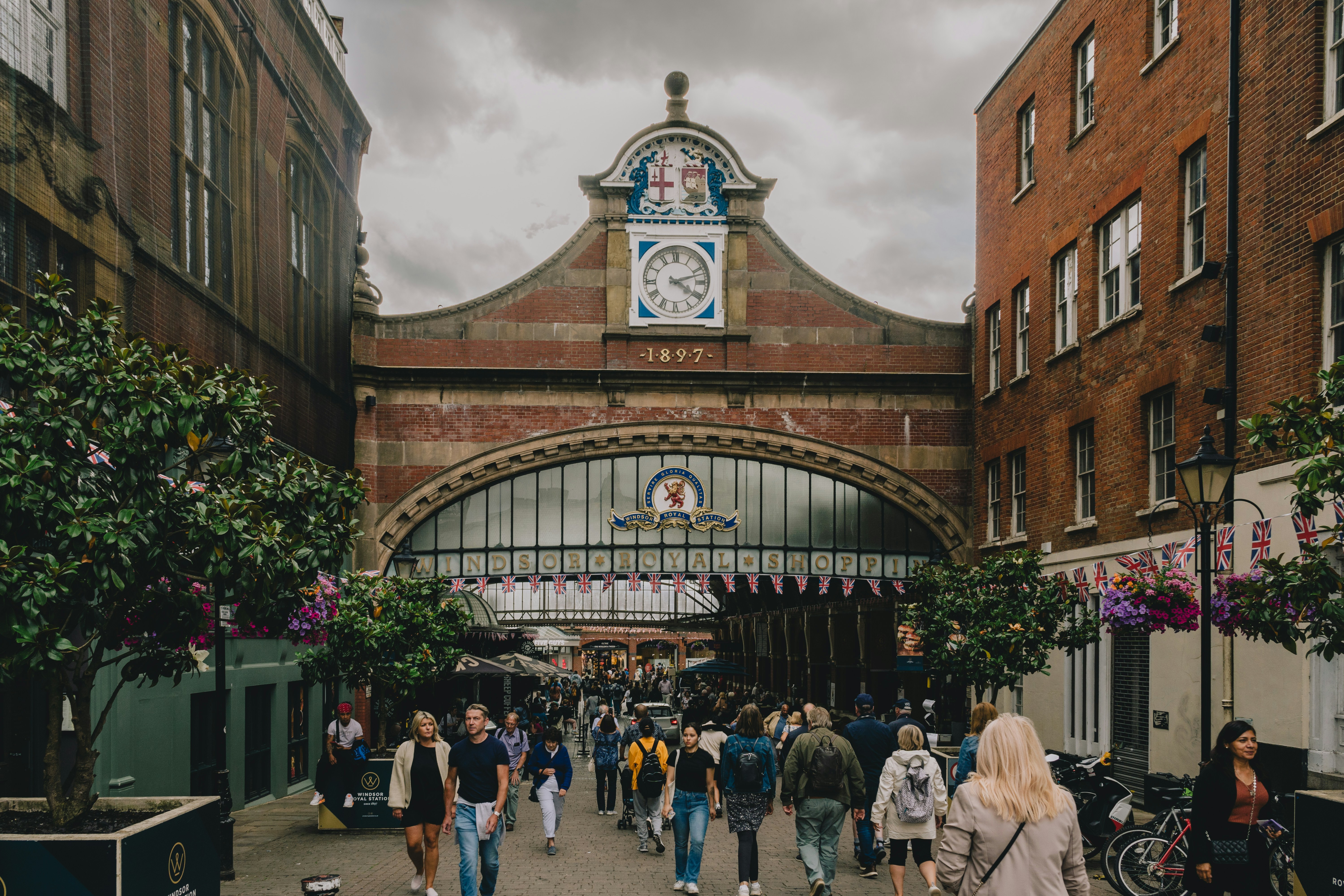 a group of people walking down a street next to tall buildings