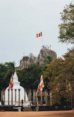a flag flying in front of a large rock formation