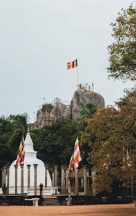 a flag flying in front of a large rock formation