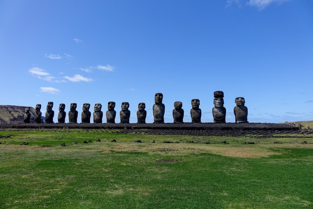 Un gran grupo de estatuas sentadas en la cima de un exuberante campo verde