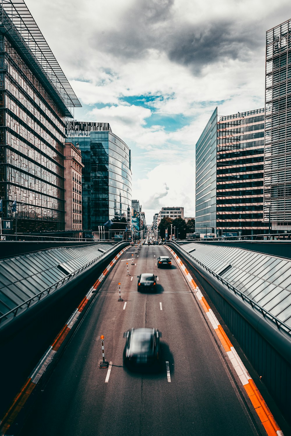 a car driving down a highway next to tall buildings