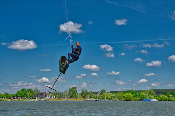 Happy customer holding a fully repaired efoil board by the water.