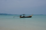 A traditional wooden boat floating on calm blue waters near a remote island.