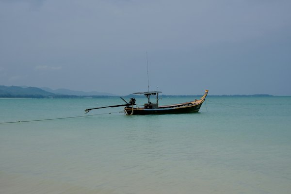 A small boat sitting in the middle of the ocean — Koh Lanta, Thailand