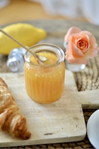 A jar of fig jam surrounded by fresh figs and a vintage knife on a linen cloth.