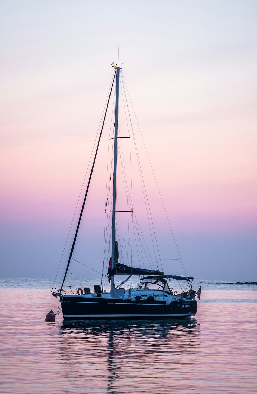 a sailboat in the water at sunset