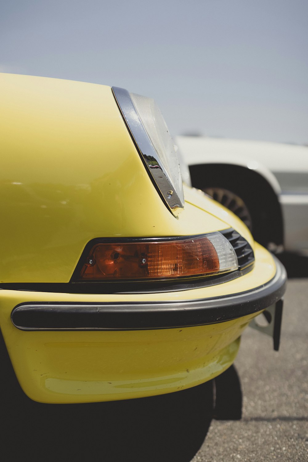 a close up of a yellow car parked in a parking lot