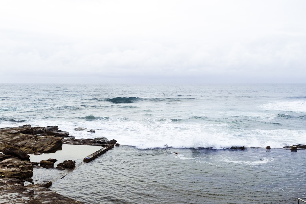 a body of water next to a rocky shore