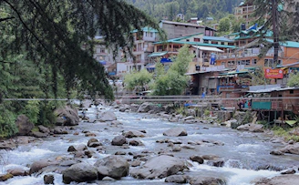 A vibrant riverside village in the Amazonas province with lush green rainforest in the background.