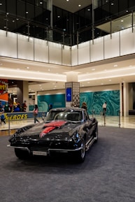 The paint and detail area showcasing vibrant red and black walls with cars being prepped for finishing touches.