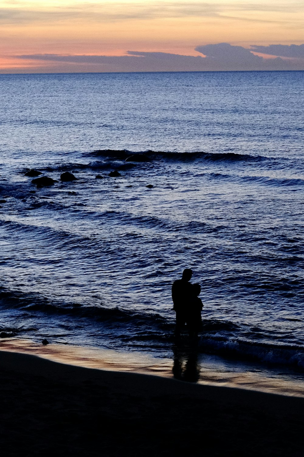 a man standing on a beach next to the ocean