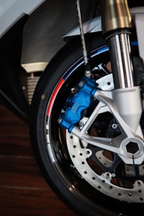 Close-up of shiny new motorcycle brake discs and pads neatly arranged on a workshop table.