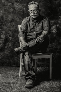 A thoughtful portrait of Andrey Kudeyev surrounded by books and notes, reflecting his deep engagement with philosophy.