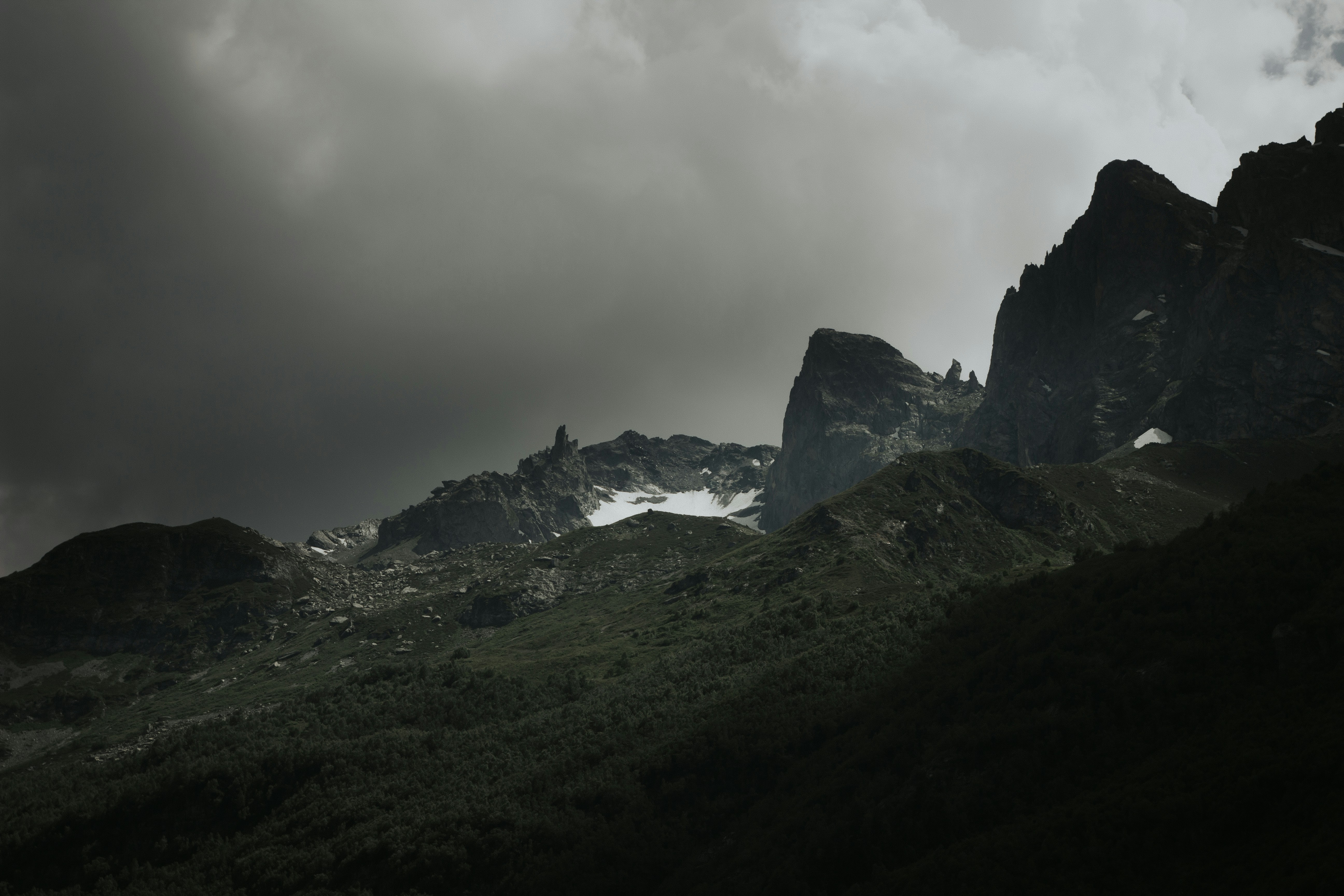 a group of mountains under a cloudy sky