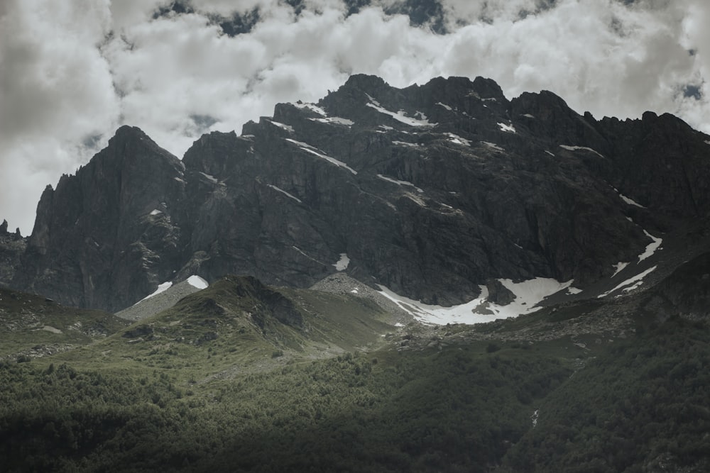 a mountain range covered in snow and clouds