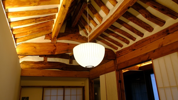 Spacious room with traditional wooden ceiling beams and soft lighting.