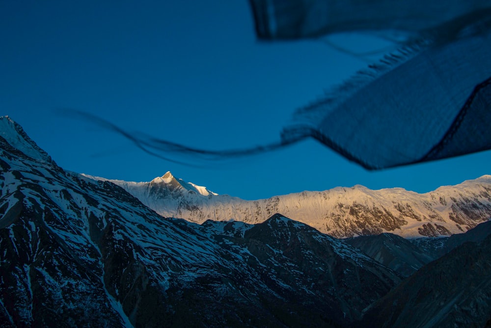 a view of a snowy mountain range at night