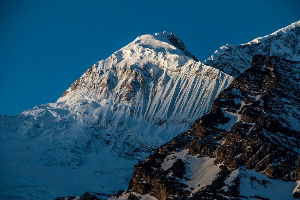 a snow covered mountain with a blue sky in the background