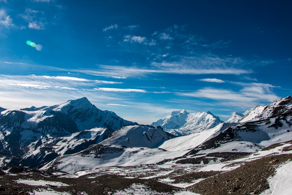 a snow covered mountain range under a blue sky