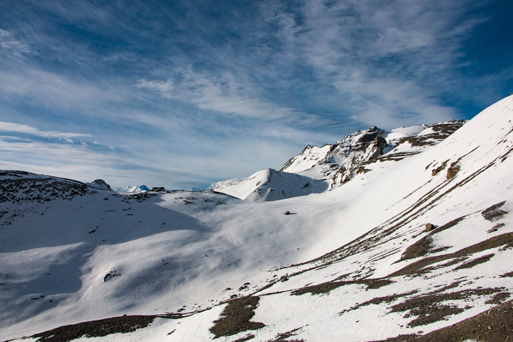 Ein schneebedeckter Berg mit ein paar Wolken am Himmel