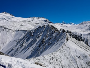 a snow covered mountain with a blue sky in the background